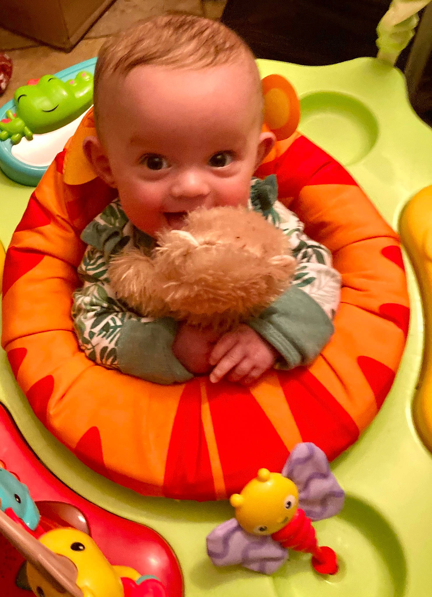 Susie is registered to the contest to win money with this photo: baby, baby_products, cheek, child, facial_expression, fun, green, happy, human_body, mouth, orange, organ, person, product, red, smile, stuffed_toy, sweetness, toddler, toy
