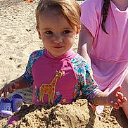 Maisie joined the competition — help win amazing prizes! beach, child, cloudy, footwear, giraffe, hat, outdoor, people, pink_clothing, play, sand, sandcastle, sea, sky, summer, sunny, swimsuit, tent, toddler, water