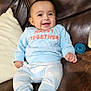 Rey joined the competition — help win amazing prizes! baby, smiling, child, infant, blue_clothing, sitting, couch, leather, pillow, pacifier, happy, face, person, indoor, cute, young_child, cozy, casual, expression, comfort