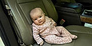 Ivy joined the competition — help win amazing prizes! baby, infant, car_interior, car_seat, leather_seat, pink_onesie, child, person, window, door, seatbelt, headrest, curious, portrait, sitting, vehicle, interior, young_child, cute, relaxed