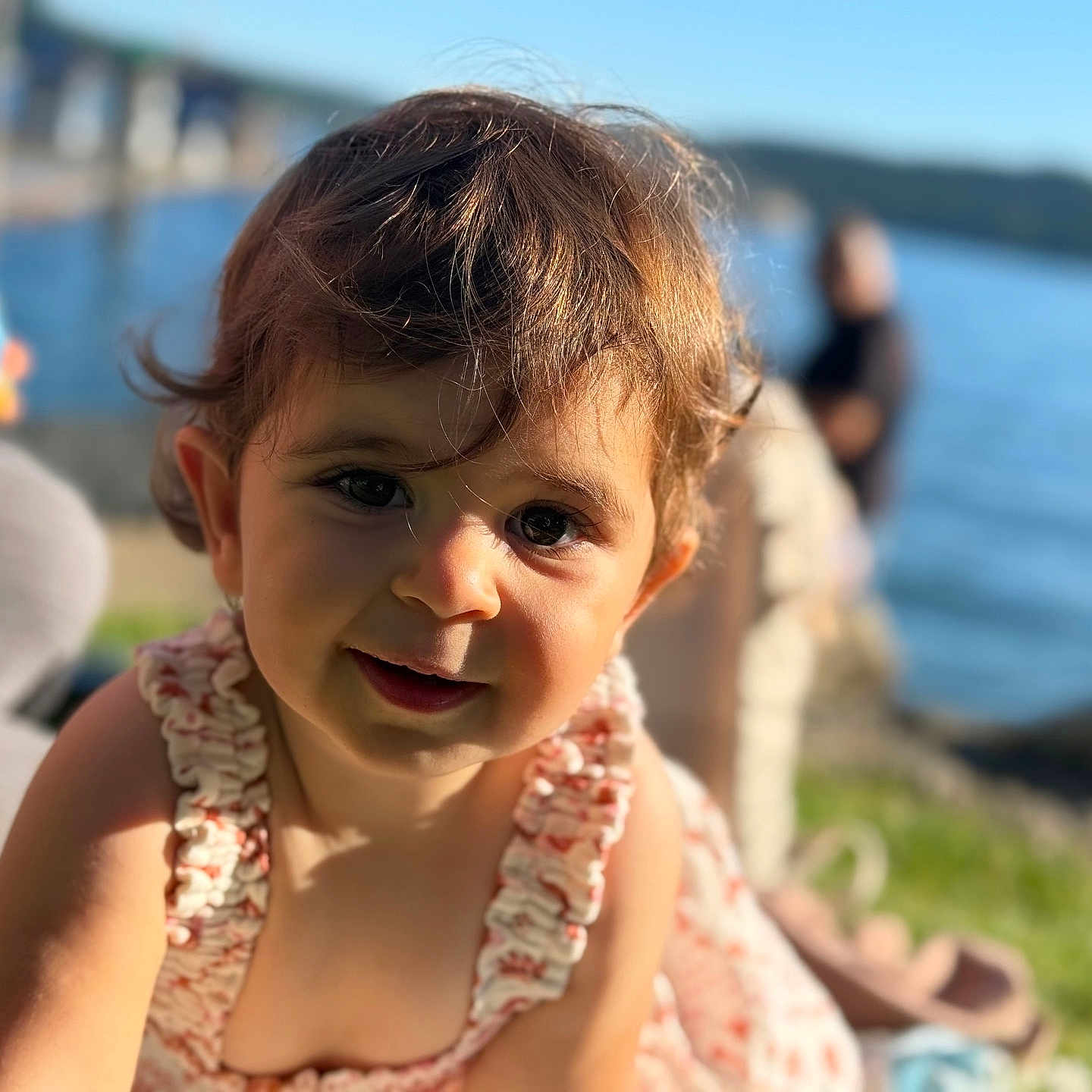 Gayane is registered to the contest to win money with this photo: child, curly_hair, cute, daylight, dress, face, grass, hair, happy, lake, nature, outdoor, person, portrait, rocks, skin, smiling, sunlight, toddler, water