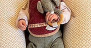 Jeanne a rejoint le concours — aidez-le/la à gagner de superbes lots ! baby, infant, child, knitted_toy, elephant_toy, bib, ribbed_pants, pillow, patterned_pillow, couch, cozy, cute, indoors, person, smiling, happy, wearing_clothes, sitting, hand, face