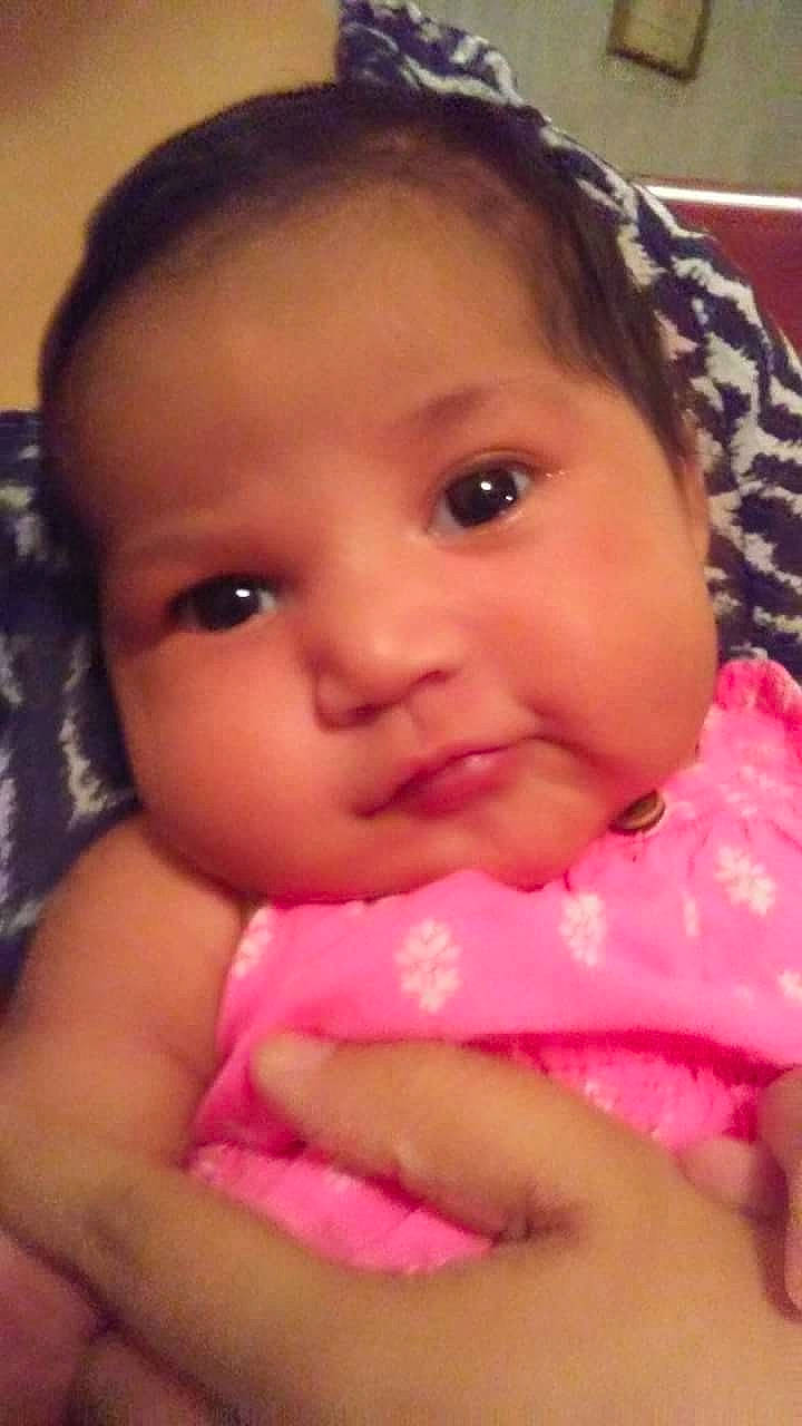 Brandi is registered to the contest to win money with this photo: black_hair, cheek, child, chin, close_up, eye, eyebrow, face, finger, forehead, girl, head, human_hair_color, infant, lip, mouth, nose, person, pink, skin