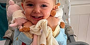 Maëlys a rejoint le concours — aidez-le/la à gagner de superbes lots ! baby, baby_item, child, clothing, cute, face, feeding_chair, furniture, happy, high_chair, holding, home, indoor, infant, person, plush_toy, smiling, table, toddler, toy