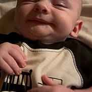 Austin is registered to the contest to win money with this photo: baby, infant, smile, face, hand, clothing, black_and_white, sleep, cute, portrait, closeup, child, newborn, soft_light, indoors, skin, person, apparel, baby_garment, expression