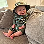baby, child, smiling, couch, hat, clothing, indoors, person, cute, seated, happy, infant, face, legs, feet, apparel, pattern, home, portrait, cozy