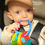 Kyler joined the competition — help win amazing prizes! baby, child, blue_eyes, teething_toy, car_seat, safety_harness, infant, cute, closeup, hand, clothing, indoor, shadow, soft_light, skin, face, expression, toy, seatbelt, young