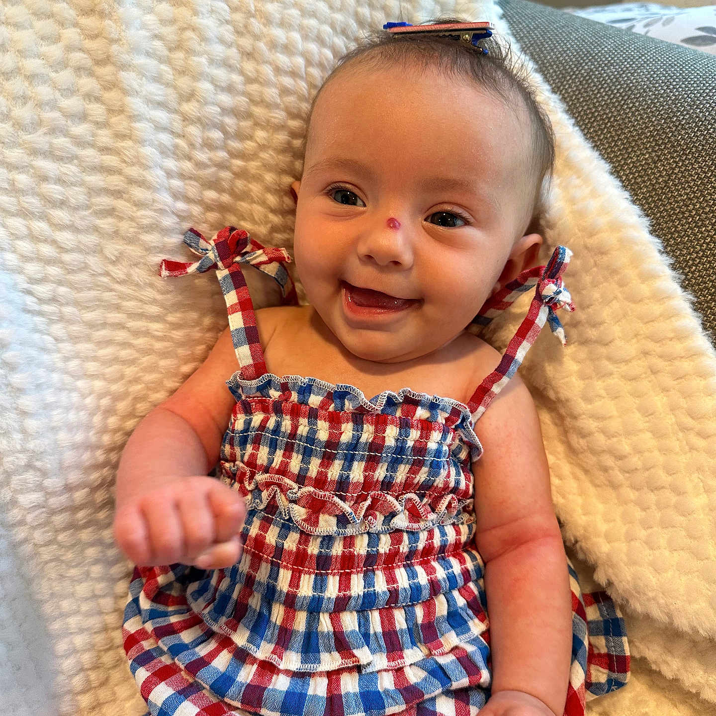 Sophia Grace joined the competition — help win amazing prizes! baby, blanket, checkered_pattern, child, clothing, cozy, cute, dress, fabric, face, hair_clip, hands, happy, head, indoor, infant, portrait, sitting, smiling, soft_texture