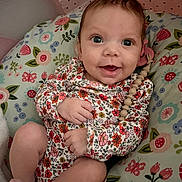 Aaliyah joined the competition — help win amazing prizes! baby, infant, smiling, cute, onesie, floral_pattern, pacifier_clip, cushion, flower, pink, star_pattern, happy, child, portrait, indoors, skin, face, hand, foot, seated