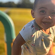Elyssia is registered to the contest to win money with this photo: child, toddler, smiling, outdoor, playground, sunlight, happy, face, short_sleeve_shirt, colorful, grass, daylight, person, cute, young, nature, fun, joy, baby, park