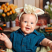 Ethan is registered to the contest to win money with this photo: baby, infant, bunny_ears, headband, blue_shirt, wicker_basket, smile, chubby_cheeks, portrait, studio_photo, tulips, flowers, props, blanket, cute, happy, eyes, sitting, spring, indoor