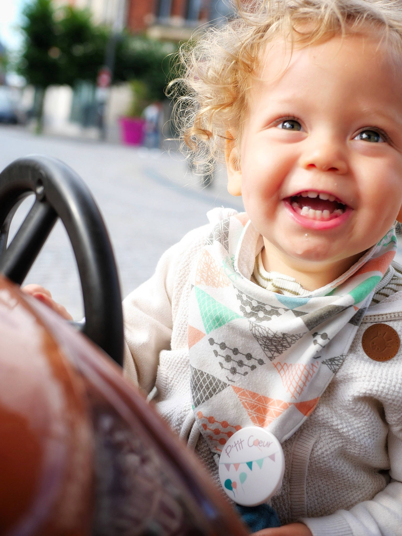 Marceau a rejoint le concours — aidez-le/la à gagner de superbes lots ! baby, baby_toddler_clothing, blond, child, fun, grass, happy, iris, joy, leisure, lip, motor_vehicle, nose, pattern, person, sitting, skin, smile, steering_wheel, toddler