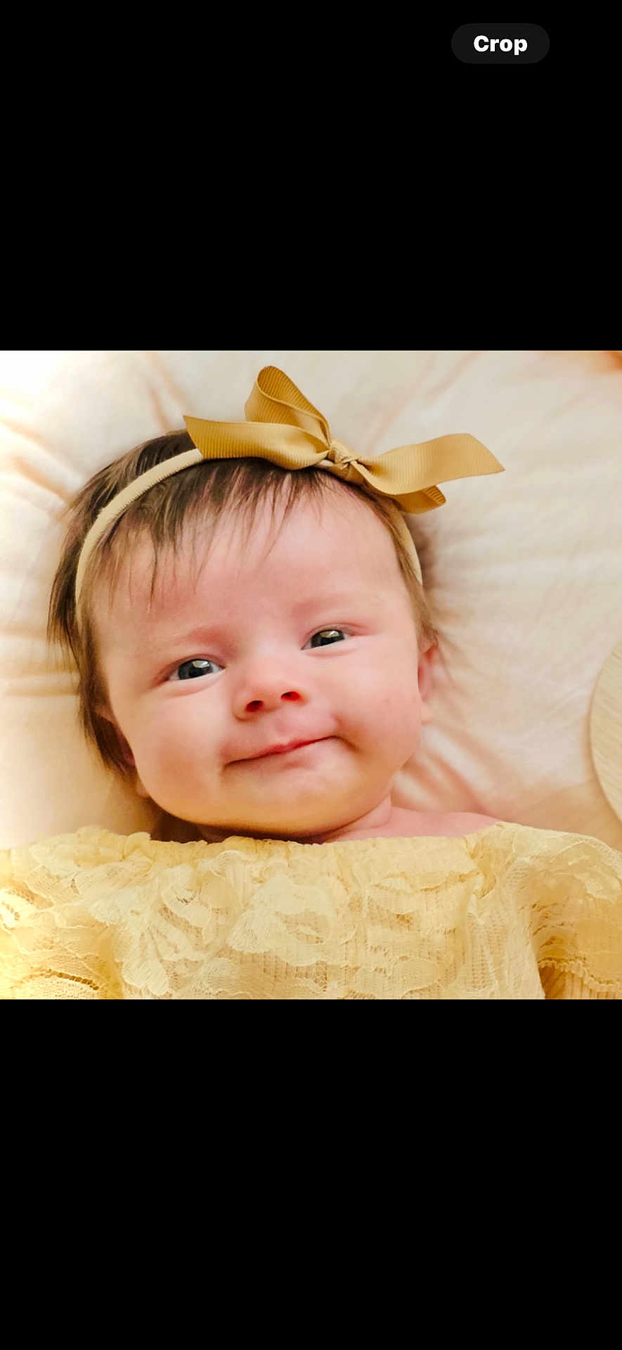 Nova joined the competition — help win amazing prizes! baby, infant, face, headband, bow, smile, yellow_clothing, lace, cute, child, portrait, lying_down, soft_lighting, indoors, cushion, cozy, happy, skin, young, adorable