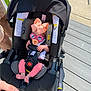 Juniper is registered to the contest to win money with this photo: baby, stroller, sunglasses, bow, pacifier, infant, child, outdoor, sunlight, clothing, feet, hand, person, safety_harness, car_seat, toy, pink, black, gray, relaxing