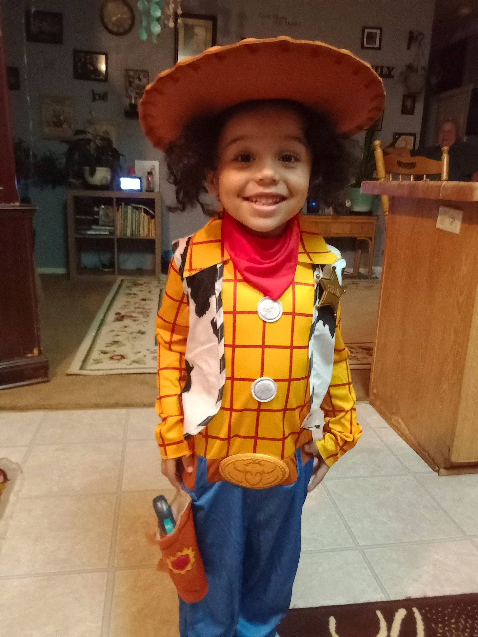 William is registered to the contest to win money with this photo: child, costume, costume_hat, fashion_accessory, flooring, fun, happy, hat, joy, leisure, orange, person, room, sleeve, smile, standing, sun_hat, toddler, travel, trick_or_treat