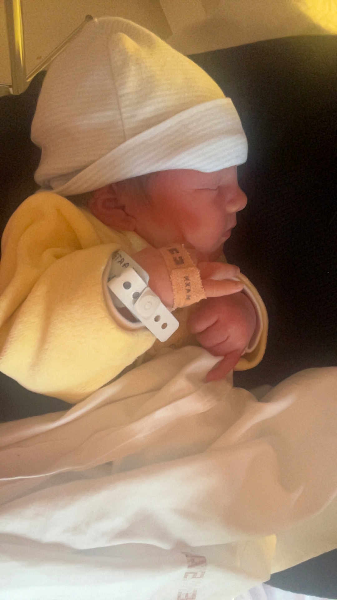 Ezio a rejoint le concours — aidez-le/la à gagner de superbes lots ! newborn, baby, sleeping, hat, yellow_clothing, blanket, hospital_band, infant, side_profile, peaceful, indoors, soft_light, cute, tiny_hands, wrapped, resting, close_up, child, person, warm