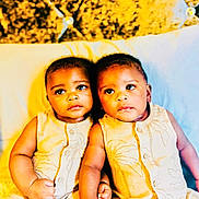 Alph Twins joined the competition — help win amazing prizes! baby, babies, twin_babies, infant, yellow_outfit, bed, pillow, headboard, cute, child, portrait, indoor, sitting, holding_hands, matching_clothes, young_child, adorable, people, skin, expression