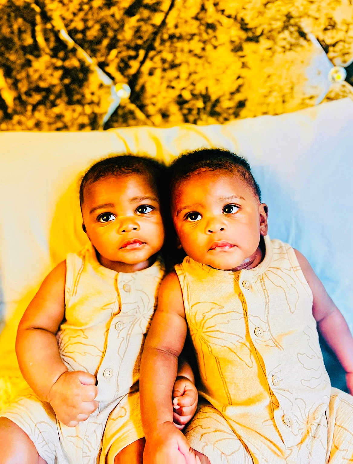 Alph Twins joined the competition — help win amazing prizes! baby, babies, twin_babies, infant, yellow_outfit, bed, pillow, headboard, cute, child, portrait, indoor, sitting, holding_hands, matching_clothes, young_child, adorable, people, skin, expression