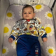 Mateo is registered to the contest to win money with this photo: baby, infant, child, crib, bassinet, blanket, daisy_pattern, cartoon_print, looney_tunes, bugs_bunny, taz, pajamas, socks, face, portrait, indoor, mattress, nursery, lying_down, warning_label