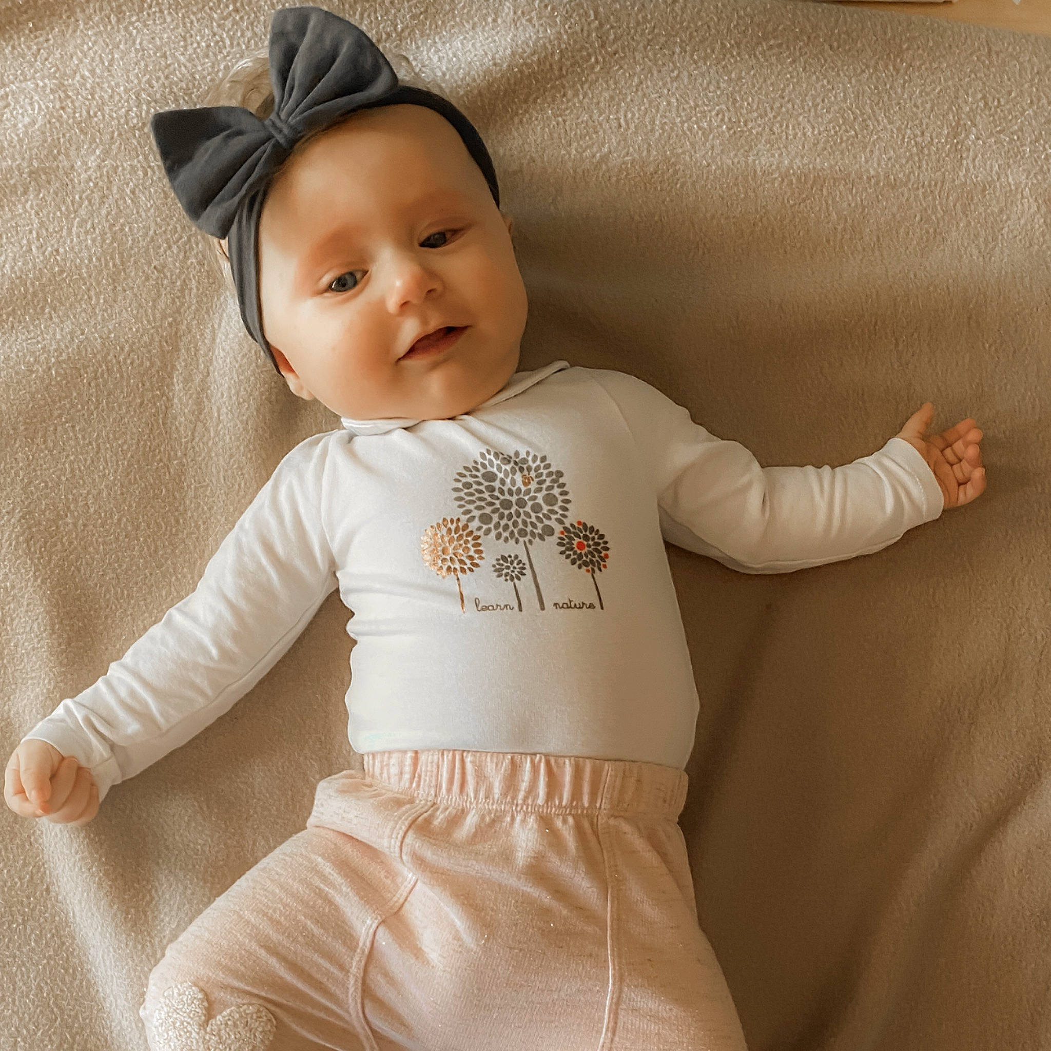 Chloé participe au concours pour gagner de l'argent avec cette photo : arm, baby, baby_products, baby_toddler_clothing, beige, child, clothing, ear, headwear, joint, long_sleeved_t_shirt, outerwear, pattern, person, product, sleeve, toddler