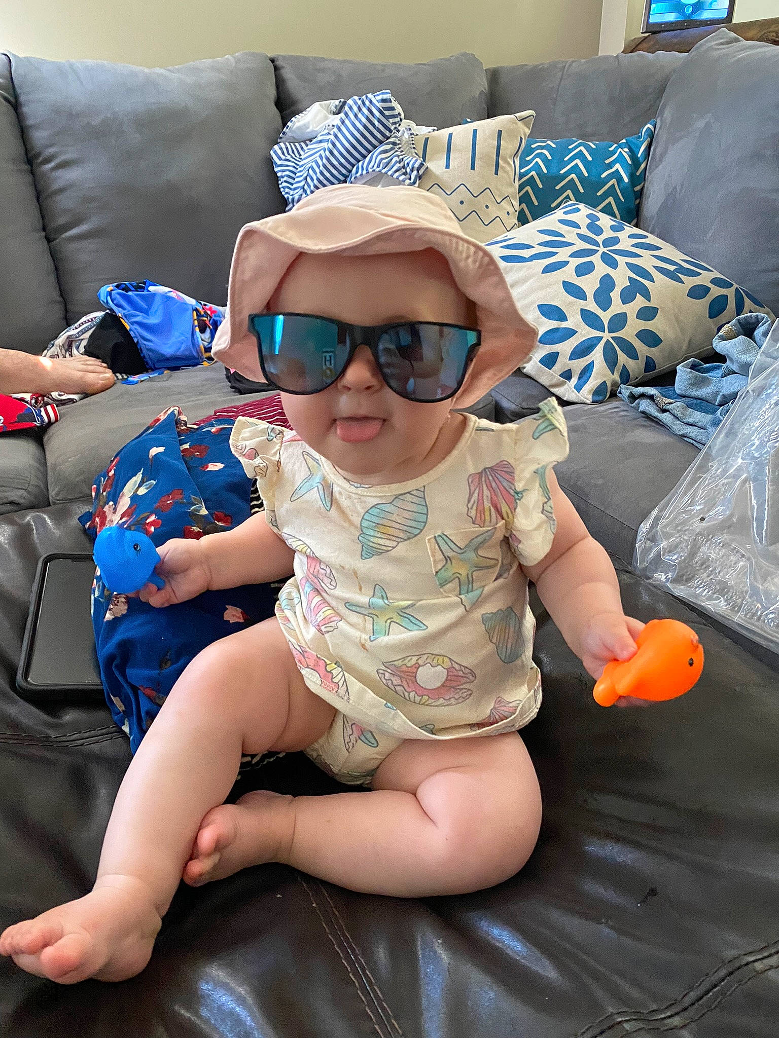 Adriana joined the competition — help win amazing prizes! arm, baby, baby_toddler_clothing, blue, cap, comfort, eyewear, glasses, goggles, hat, head, headgear, human_body, lap, mouth, person, skin, sunglasses, thigh, toddler