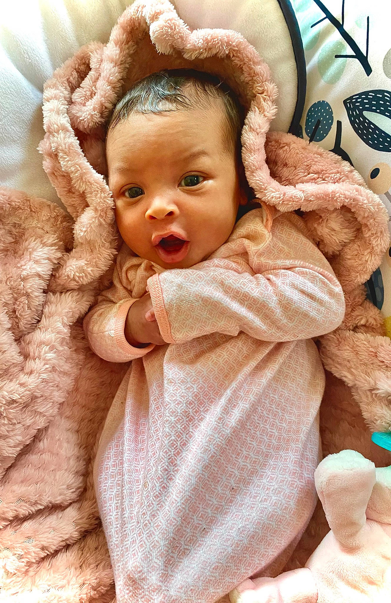 Nylah is registered to the contest to win money with this photo: baby, baby_toddler_clothing, cheek, child, comfort, ear, eyelash, finger, gesture, happy, human_body, iris, linens, lip, neck, nose, outerwear, person, skin, surprise