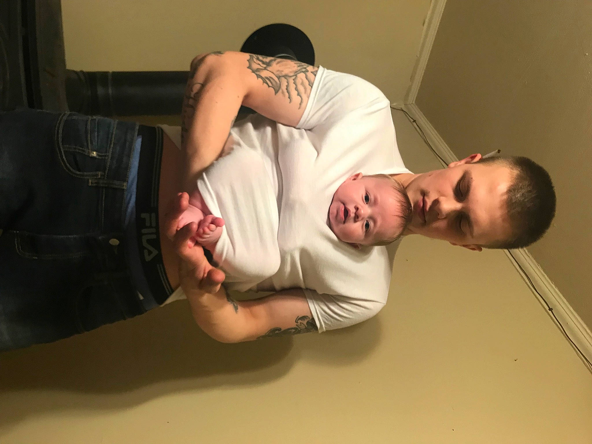 Jaxton is registered to the contest to win money with this photo: abdomen, beard, chest, comfort, elbow, eyewear, flash_photography, flooring, foot, fun, gesture, human_leg, joint, knee, luggage_and_bags, person, room, sitting, thigh, trunk