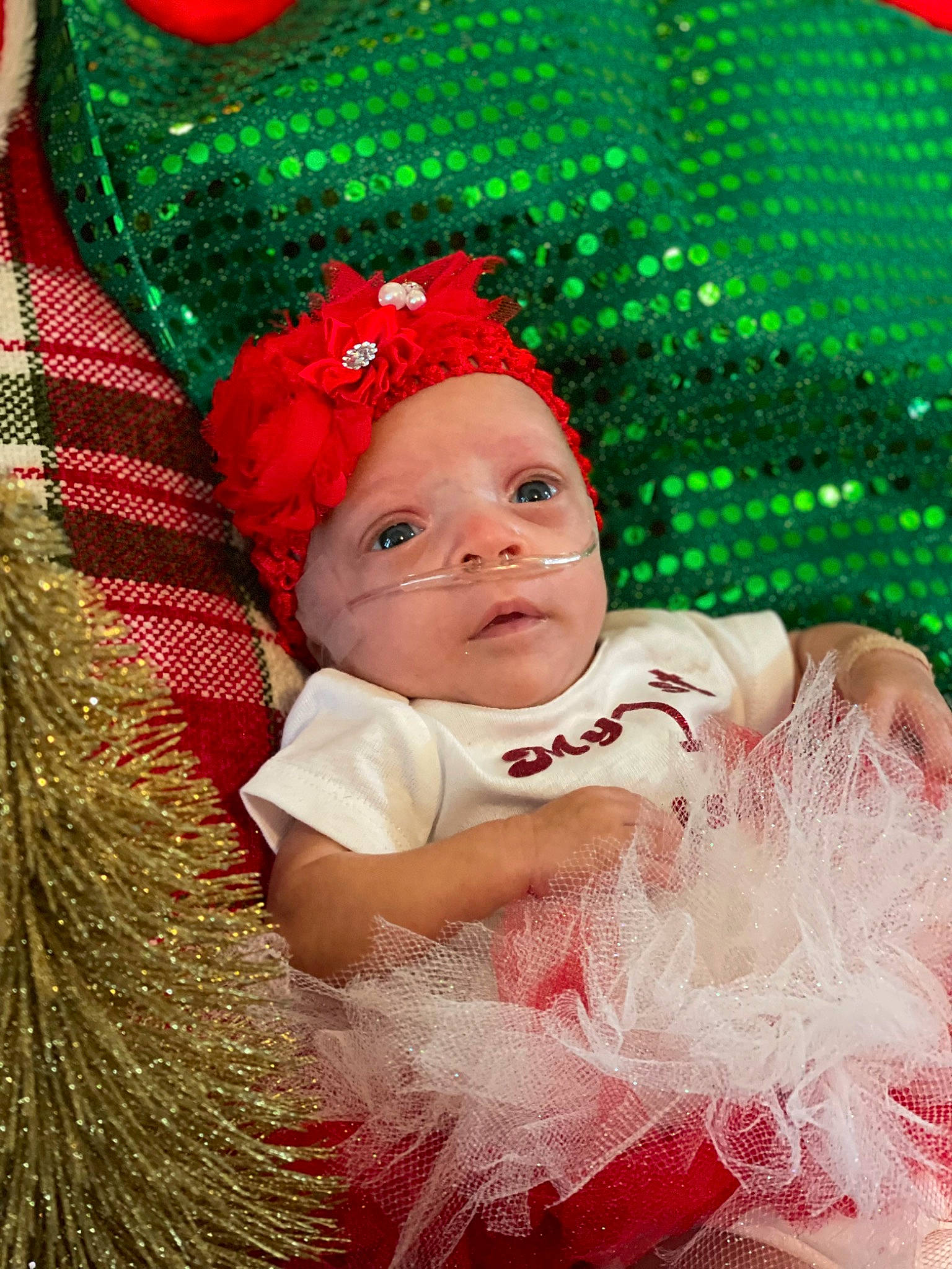 Aiyana is registered to the contest to win money with this photo: baby, baby_toddler_clothing, cap, child, christmas, christmas_decoration, christmas_ornament, costume_hat, event, facial_expression, grass, green, happy, headgear, headwear, holiday, light, people_in_nature, person, pink