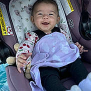 Ehlani joined the competition — help win amazing prizes! baby, car_seat, blanket, smiling, happy, child, infant, purple, clothing, face, cute, sitting, toy, pattern, black_pants, soft, indoor, comfort, young, portrait