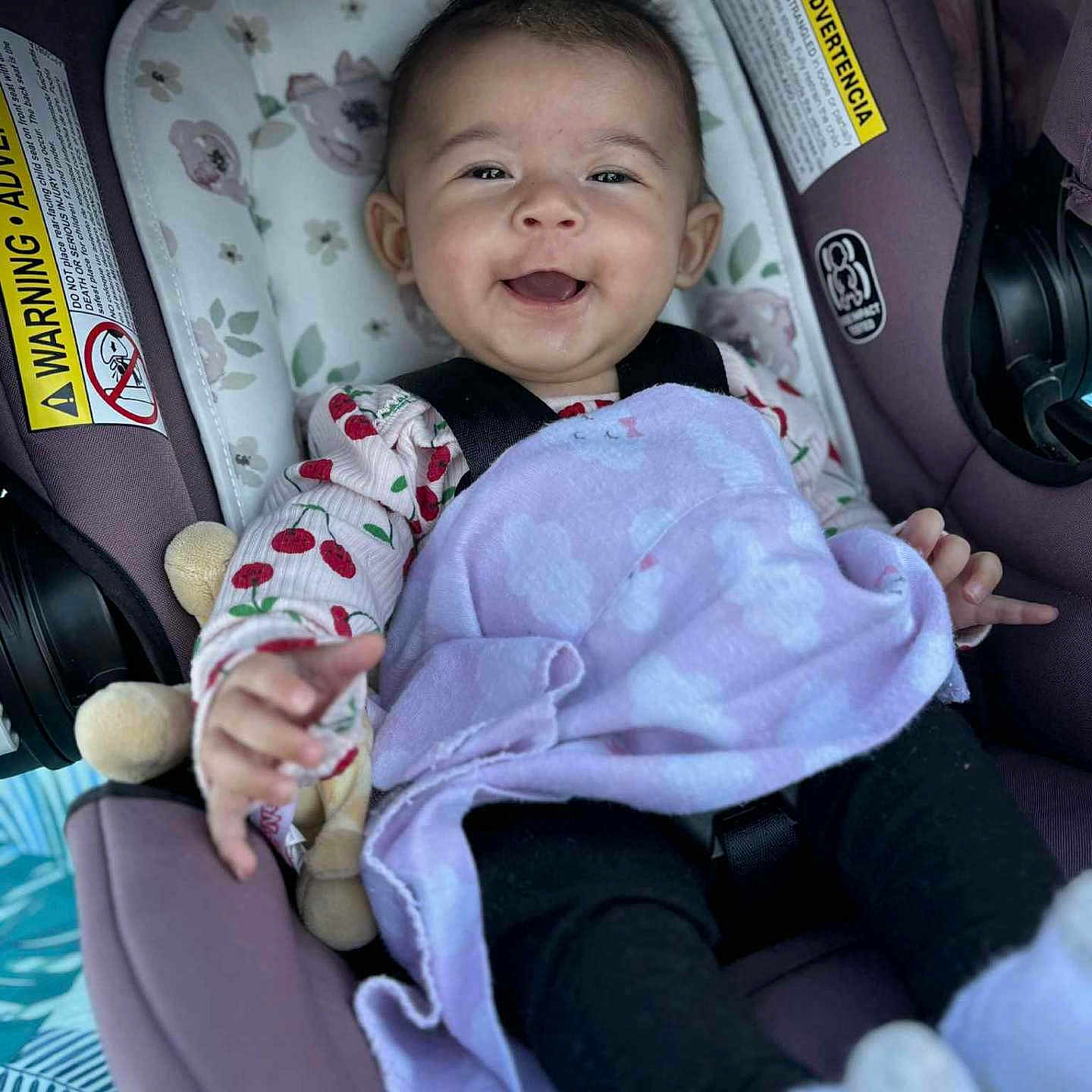 Ehlani joined the competition — help win amazing prizes! baby, black_pants, blanket, car_seat, child, clothing, comfort, cute, face, happy, indoor, infant, pattern, portrait, purple, sitting, smiling, soft, toy, young
