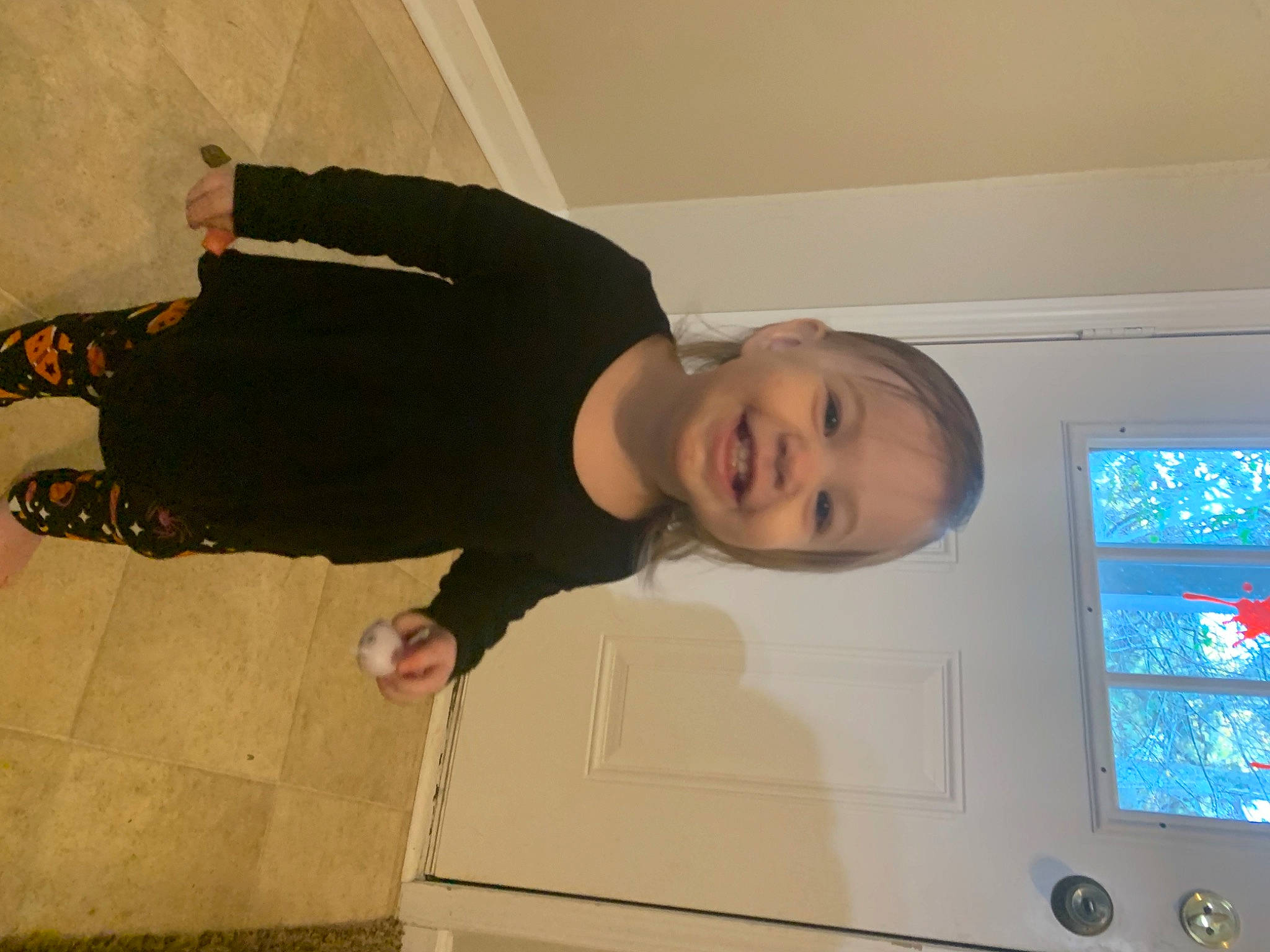 Emberly is registered to the contest to win money with this photo: automotive_exterior, child, display_device, family_car, finger, flooring, fun, home_appliance, joy, luxury_vehicle, machine, major_appliance, person, room, smile, standing, t_shirt, television_set, toddler, tree