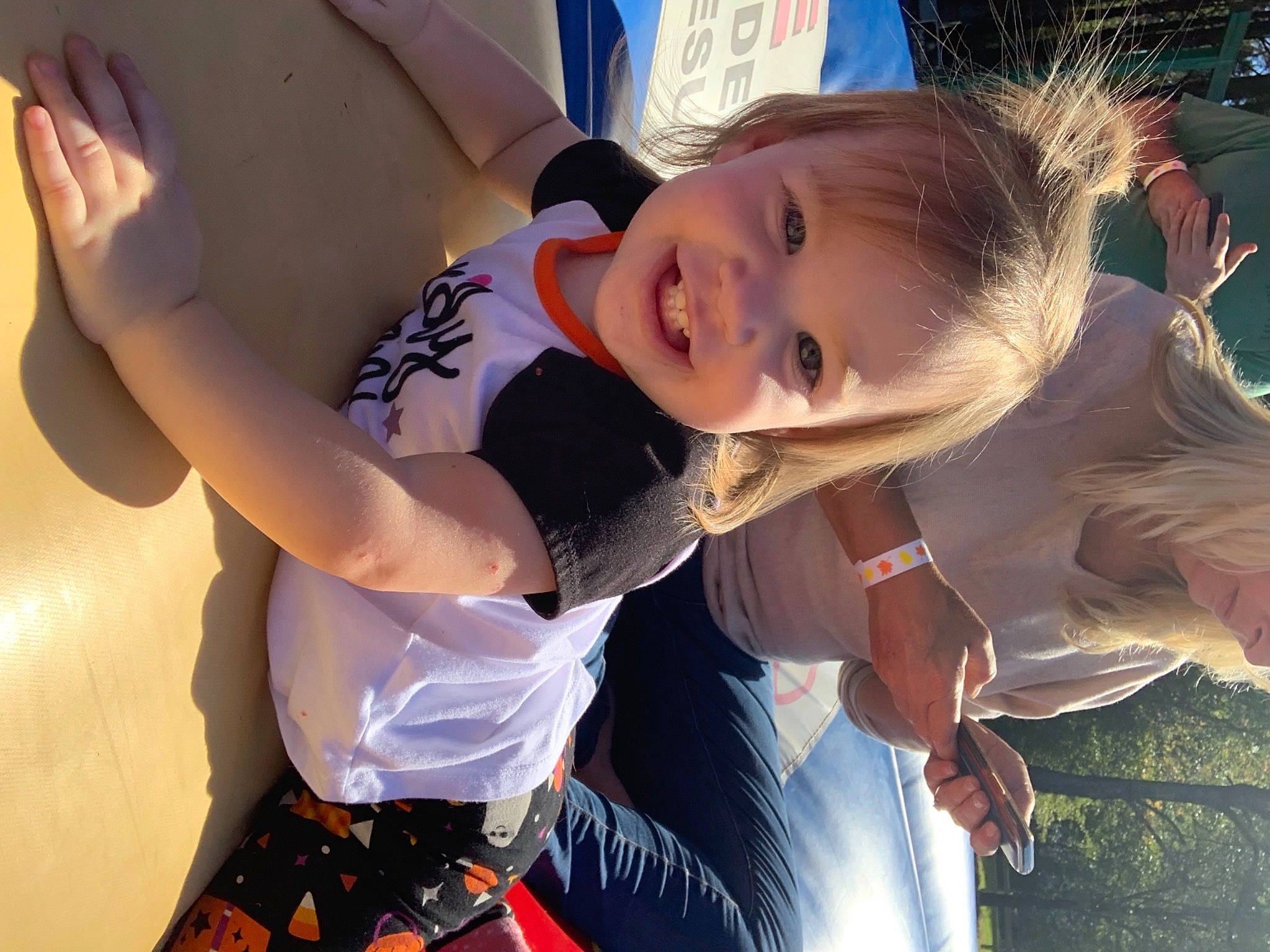 Emberly is registered to the contest to win money with this photo: baby, child, event, flash_photography, fun, gesture, grass, hairstyle, happy, interaction, joy, leisure, people_in_nature, person, plant, recreation, smile, summer, toddler, tradition