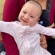 Kiana joined the competition — help win amazing prizes! baby, child, smiling, face, person, holding, clothing, pink_outfit, floral_pattern, arm, adult, closeup, portrait, happy, cute, infant, skin, eyes, head, warmth