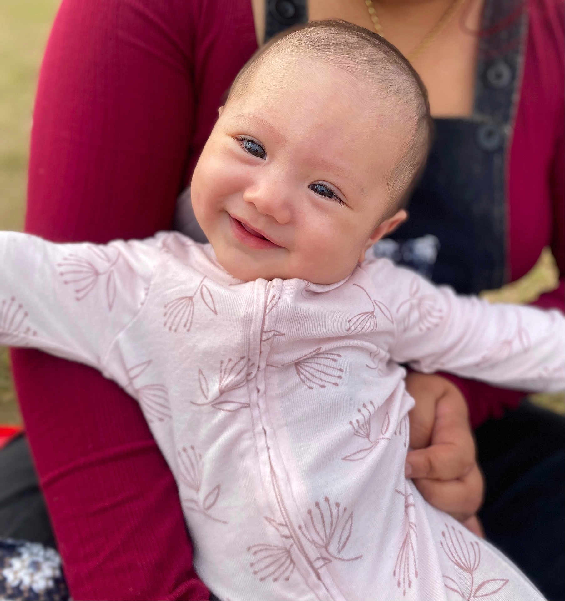 Kiana joined the competition — help win amazing prizes! baby, child, smiling, face, person, holding, clothing, pink_outfit, floral_pattern, arm, adult, closeup, portrait, happy, cute, infant, skin, eyes, head, warmth