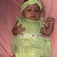 Leah joined the competition — help win amazing prizes! baby, infant, child, portrait, lying_down, pink_blanket, green_outfit, headband, bow, flower, dress, onesie, smiling, face, hands, fist, indoor, bedding, fashion, photography