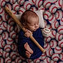 Easton is registered to the contest to win money with this photo: baby, newborn, sleeping, swaddled, blue_cloth, baseball_bat, baseball, blanket, pillow, sports_theme, infant, cute, peaceful, tiny_feet, wooden_bat, patterned_background, soft_lighting, portrait, indoor, resting