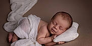 Easton joined the competition — help win amazing prizes! baby, newborn, sleeping, blanket, pillow, wrapped, soft, cute, peaceful, infant, skin, head, resting, knit, white, brown_background, portrait, closeup, child, cozy