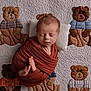 newborn, baby, sleeping, wrapped, quilt, teddy_bear, basketball, fabric, soft, cute, infant, pillow, pattern, child, resting, cozy, blanket, portrait, peaceful, indoors