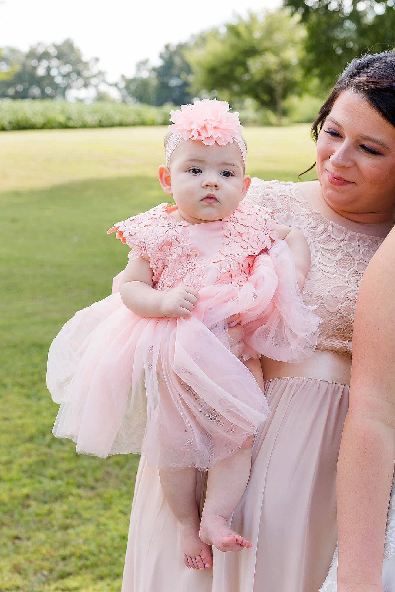 Kimber joined the competition — help win amazing prizes! baby, bridal_clothing, bridal_party_dress, bridal_veil, dress, face, flash_photography, gesture, gown, hand, happy, headpiece, headwear, human_body, interaction, joy, people_in_nature, person, petal, pink