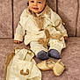 Adam participe au concours pour gagner de l'argent avec cette photo : baby, child, couch, cultural, cute, decor, fabric, fez_hat, footwear, furniture, happy, home, indoors, person, portrait, seated, smiling, socks, traditional_clothing, young_child