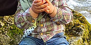 Adam a rejoint le concours — aidez-le/la à gagner de superbes lots ! cap, child, curious, expression, face, food, fruit, greenery, hand, jeans, moss, nature, outdoor, plaid_shirt, rock, sitting, sneakers, stream, toddler, water