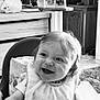 Romy participe au concours pour gagner de l'argent avec cette photo : baby, bib, black_and_white, cabinet, carpet, child, curtain, face, flower, furniture, happy, high_chair, home, indoor, person, plant, portrait, smile, table, window