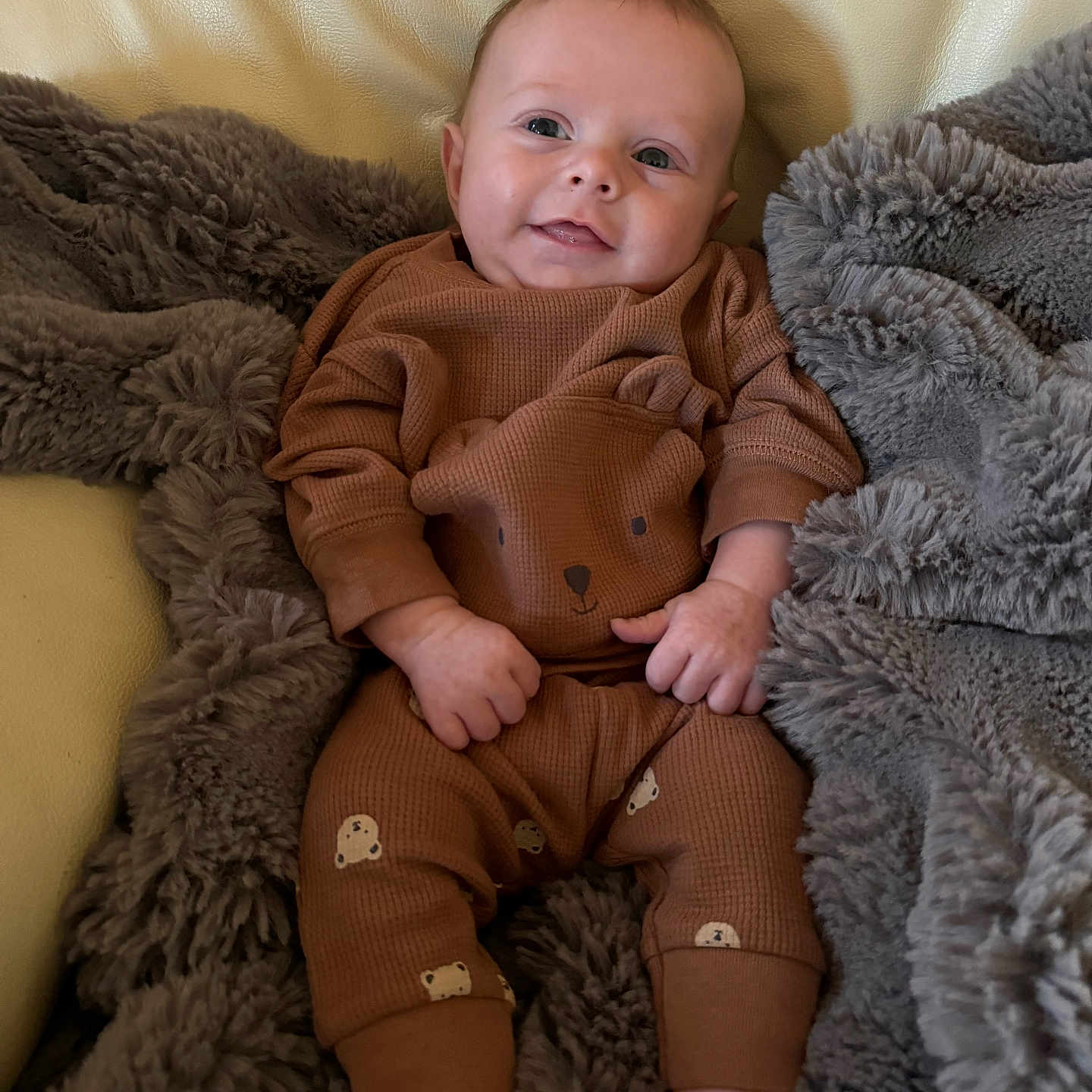 Evren joined the competition — help win amazing prizes! baby, bear_print, blanket, brown_clothing, child, comfort, couch, cozy, cute, face, furniture, happy, indoor, infant, portrait, relaxing, small_feet, small_hands, smiling, soft_texture
