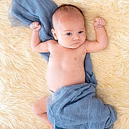 Maverick joined the competition — help win amazing prizes! baby, infant, blue_cloth, fluffy_rug, skin, bare_chest, lying_down, raised_arms, curious_expression, soft_texture, blanket, newborn, cute, child, portrait, indoors, sleeping_area, resting, comfort, toddler