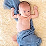 baby, infant, blue_cloth, fluffy_rug, skin, bare_chest, lying_down, raised_arms, curious_expression, soft_texture, blanket, newborn, cute, child, portrait, indoors, sleeping_area, resting, comfort, toddler