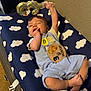 baby, balloon, blanket, blue_clothing, child, cloud_pattern, cute, foot, furniture, hand, indoors, infant, lying_down, milestone, number_three, playful, portrait, smiling, wall, wooden_sign