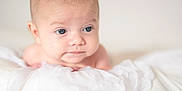 Maverick joined the competition — help win amazing prizes! baby, infant, blue_eyes, blanket, soft, white, cute, portrait, child, skin, head, expression, lying_down, newborn, indoors, young, person, closeup, face, peaceful