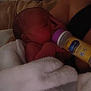 Angel is registered to the contest to win money with this photo: baby, newborn, bottle, feeding, blanket, arm, person, indoor, skin, sleeping, rest, comfort, couch, soft, closeup, infant, care, parent, holding, peaceful