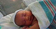 Angel is registered to the contest to win money with this photo: baby, bassinet, blanket, child, closed_eyes, cute, hat, hospital, indoors, infant, newborn, newborn_baby, peaceful, person, portrait, resting, skin, sleeping, towel, wrapped