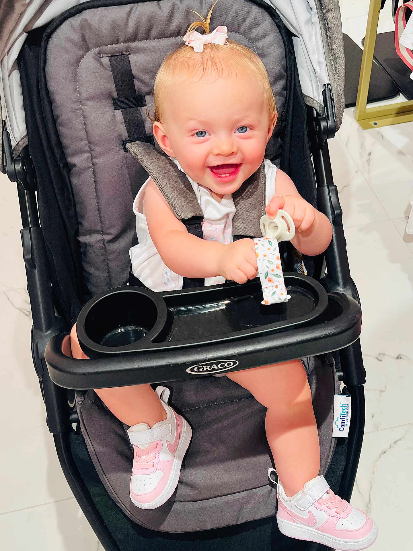 Blakelynn joined the competition — help win amazing prizes! baby, stroller, smiling, child, pink_bow, pacifier, sneakers, white_shoes, happy, indoor, floor, toy, person, seat, graco_brand, clothing, infant, cute, playful, accessory